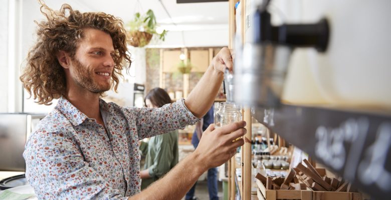 Man Filling Container With Dishwasher Powder In Plastic Free Grocery Store